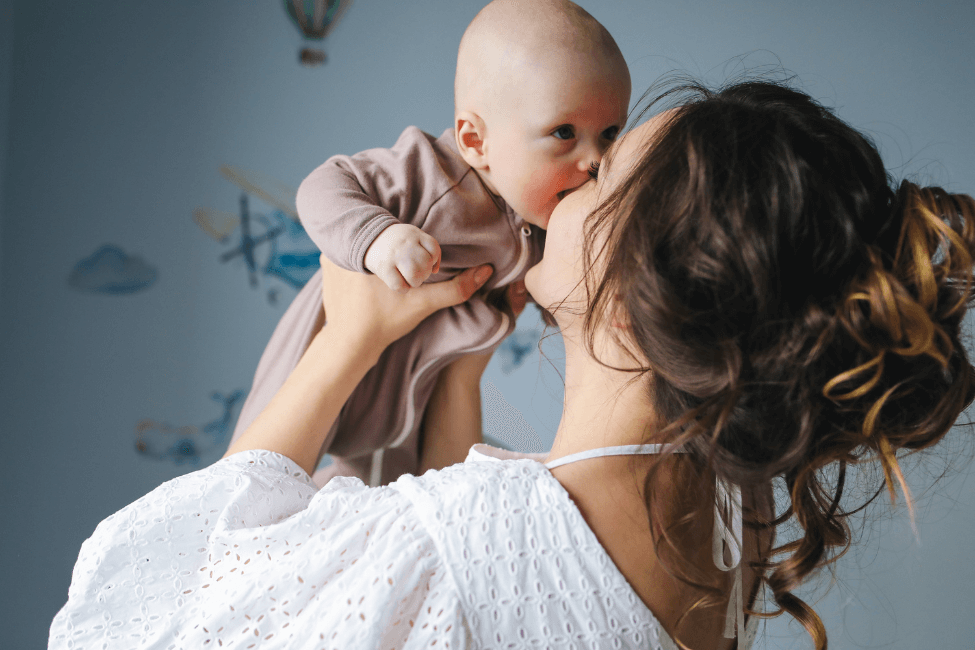 Kvinde kysser baby kærligt
